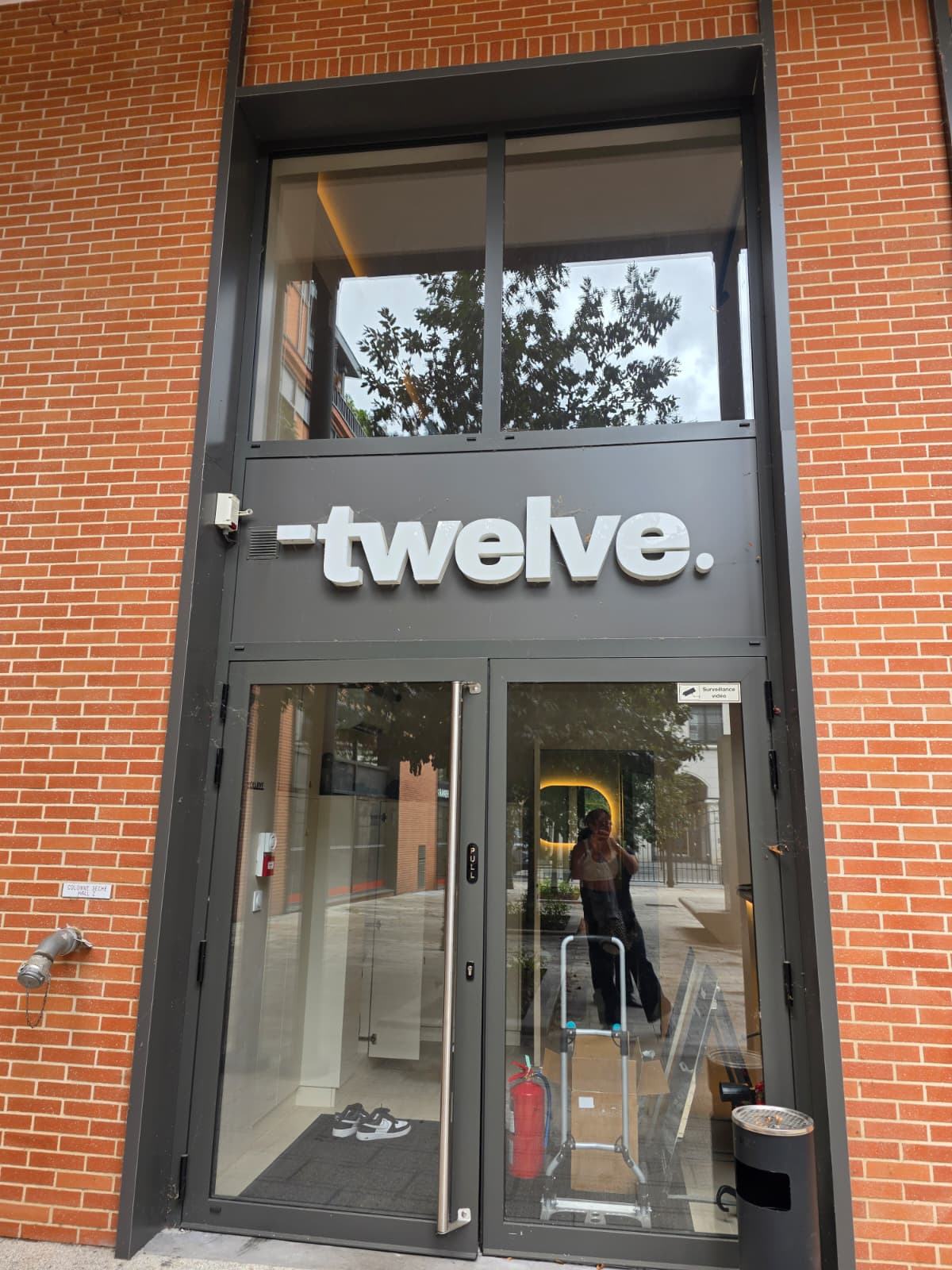 Entrée vitrée et panneau de l’enseigne avant intervention